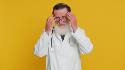 Senior Doctor Frustrated and Concerned on Yellow Background