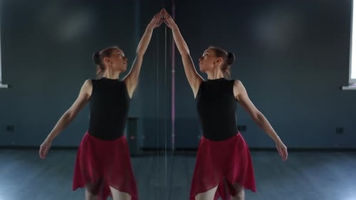 A Beautiful Ballerina Gracefully Dances with Her Reflection in the Mirror of the Choreographic Hall