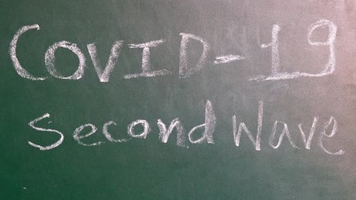 Coronavirus Secondwave text on green board panning shot closeup.