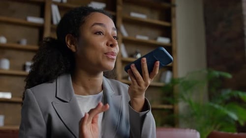Woman in Blazer Using Voice Assistant on Phone