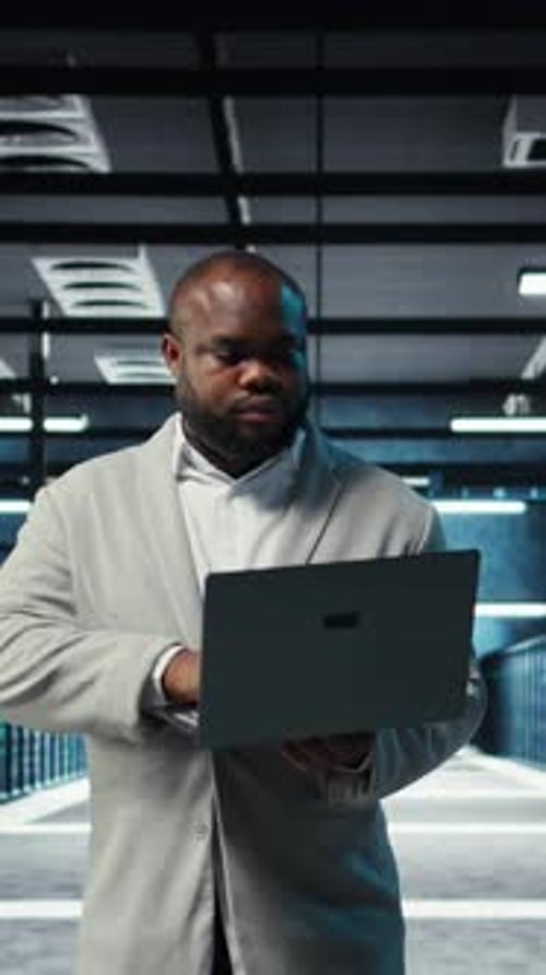 Vertical Video Data Center Computer Scientist Using Laptop to Manage System Stability