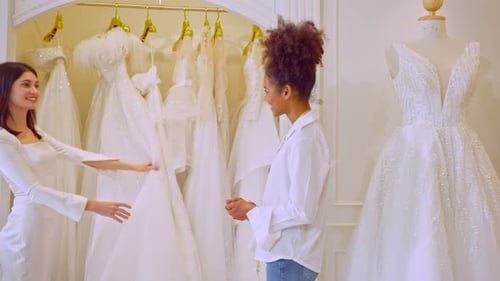 Beautiful bride discussing details with the wedding planner in studio.