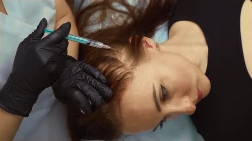 Woman Receiving Scalp Injections in a Medical Setting