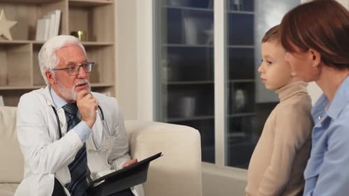 Doctor Talking with Child and Mother at Appointment