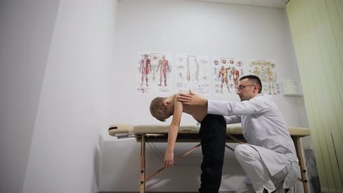 Doctor Examining a Child's Posture in Clinic