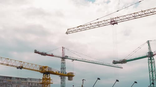 Many tower cranes work on construction site. They move and build building.