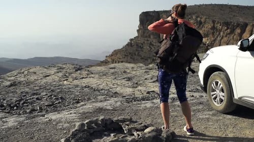Young woman trekking with backpack enjoying canyon view on summer vacation day