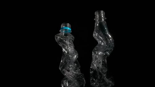 Crushed Plastic Bottles Rotating on Black Background