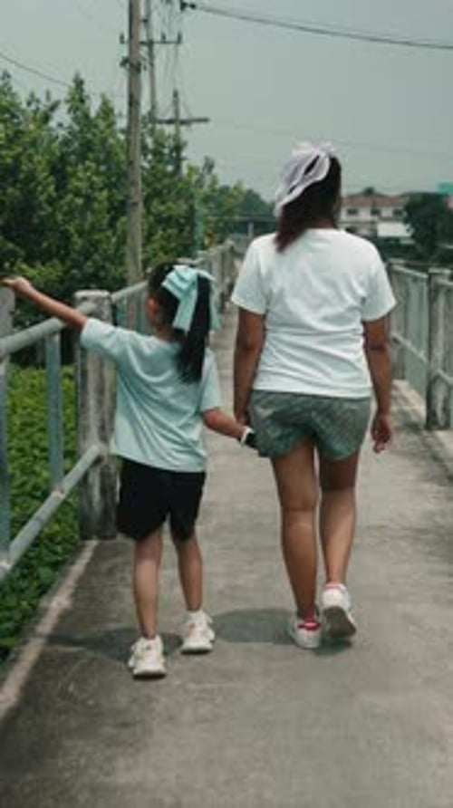 Woman Walking with Child Along Scenic Outdoor Path Sharing Intimate Moment During Family Leisure
