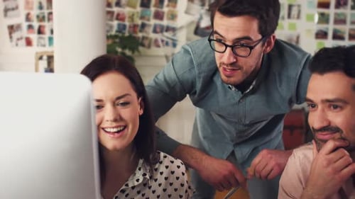 4k video footage of a group of designers working together on a computer in an office