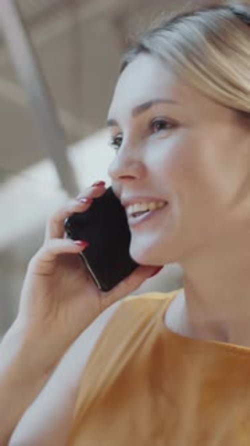 Smiling Woman Talking on Mobile Phone Indoors