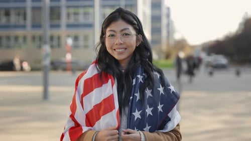 Young Woman Smiling with American Flag in City