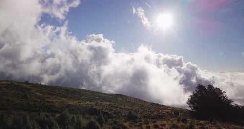 Drone dolly view over the Haleakala volcano while white clouds moving over a valley on Maui, Hawaii.