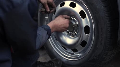 Mechanic Installing Lug Nuts on a Car Wheel