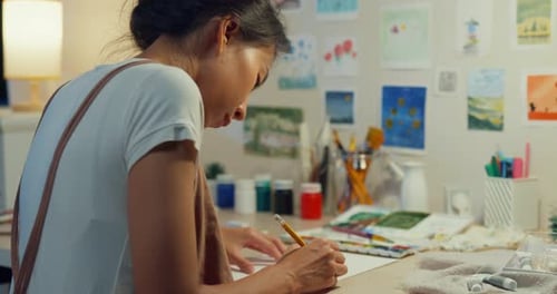 Asia lady drawing picture on sketchbook create artwork cozy workshop in home at night.