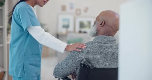 Healthcare Worker Comforts Senior Man in Wheelchair