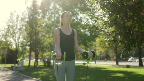 Fitnessfocused Young Woman Training with Resistance Bands in the Park