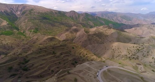 Terraced mountain hills with winding road cinematic aerial landscape