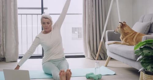 Mujer practicando yoga mientras ve un Vídeo tutorial en línea en la computadora portátil
