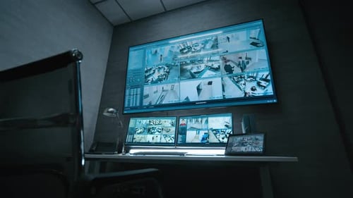 Surveillance Footage Displayed on Computer Monitors and Big Digital Screen
