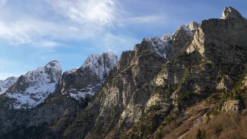 The Drone Flies Along a Mountain Range with Epic Snowy Peaks