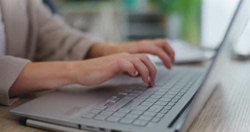 Woman in Office Writing on Laptop