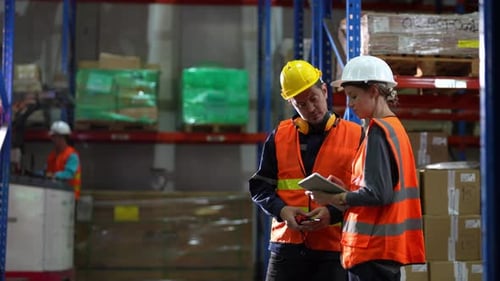 Warehouse Industrial and Logistics Companies. Dispatcher in uniform making inventory in storehouse.