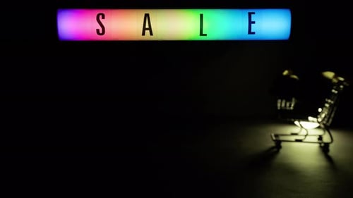 Neon Sale Sign with Shopping Cart in Dark