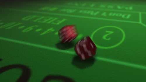 Pair of dice thrown onto a craps or crapaud table with glittering poker machines in a casino backgro