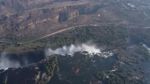 Aerial shot sees a microlight aircraft fly over the Victoria Falls in Zimbabwe, Africa.