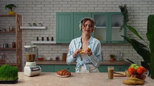 Woman Dancing and Peeling Banana in Kitchen