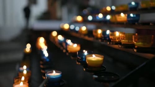 Burning Candles in Transparent Chandeliers Inside Cathedral Church