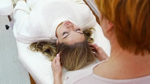 Healer Woman Performing By Touched Access Bars Therapy on Young Woman Head Stimulating Positive