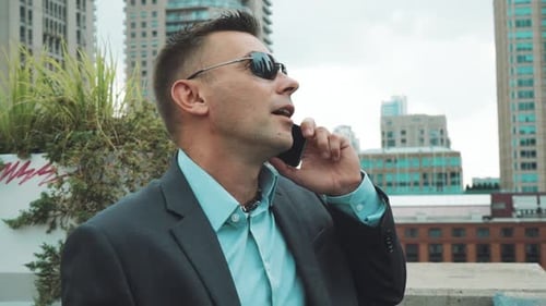Man in Suit Talking on Phone on Rooftop