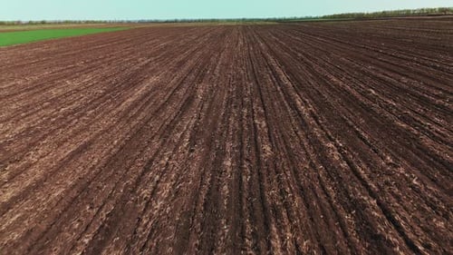 Unbewegte Bodengräben vom Ackerfeld aus gesehen, mit Furchen, die sich bis zum fernen Horizont erstrecken