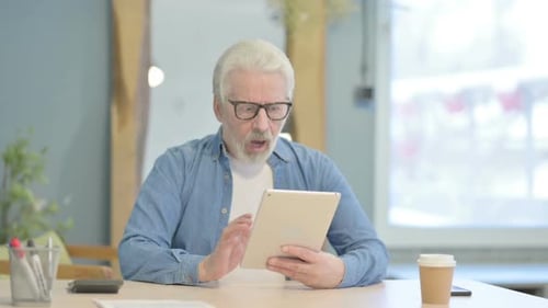 Senior Man Using Tablet at Office Desk