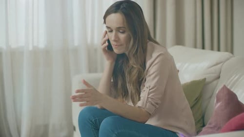 Woman Talking on Phone While Sitting on Couch