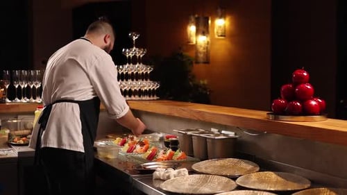 Chef prepares seafood dishes in a Japanese restaurant