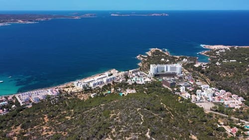 Aerial drone footage of a beach in the village of Sant Antoni on the island of Ibiza in Spain