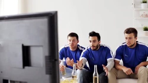Excited Men Watch Television and Cheer at Home