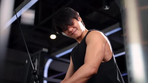 Healthy Strong Man Taking Weight Lifting with Dumbbells in Sport Club