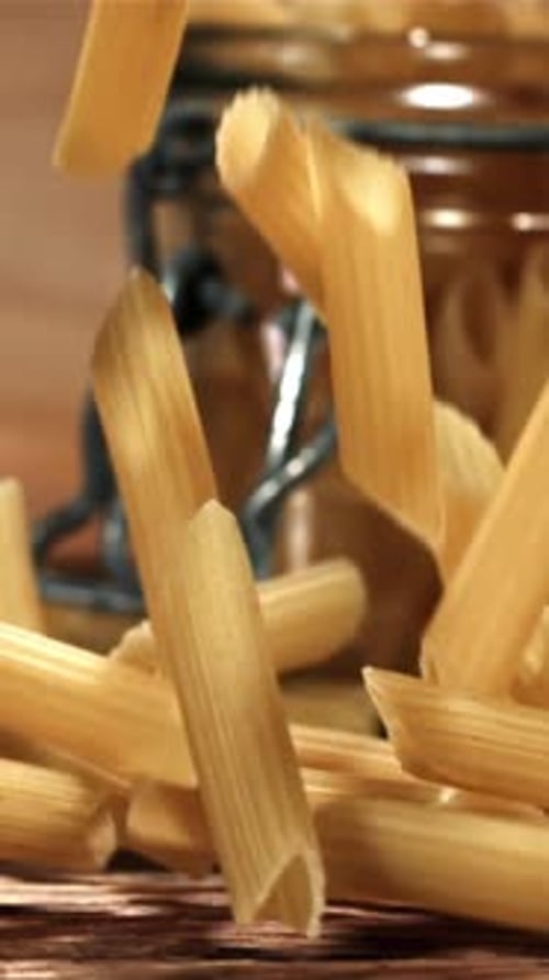 Penne Pasta Falling on a Wooden Table Filmed on a Highspeed Camera at 1000 Fps