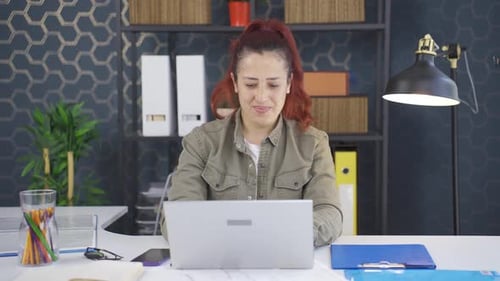 Woman Laughing Using Laptop at Modern Office Desk