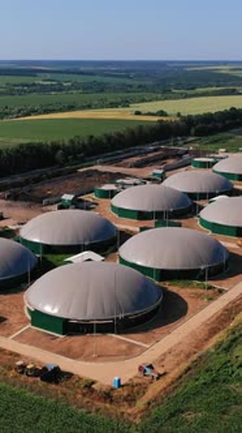 Biogas complex in the green plantations. Biogas storage tanks from the air perspective.
