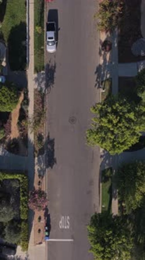 Top Down Vertical Reveal of a Los Angeles Suburban Neighborhood with Houses Cars Driving on a Street
