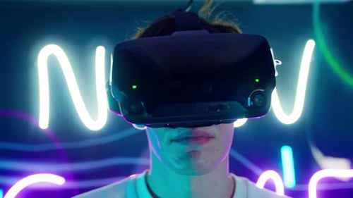 Young Adult Using VR Headset in Neon Lit Room