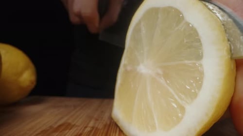 I cut the lemons into slices. Dolly slider extreme close-up.