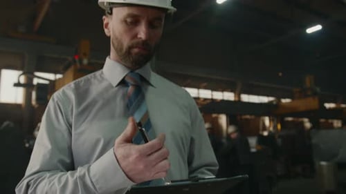 Engineer Taking Notes during Workday at Industrial Plant
