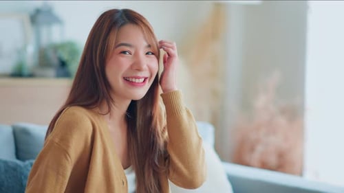 Smiling Woman Poses on a Couch Indoors