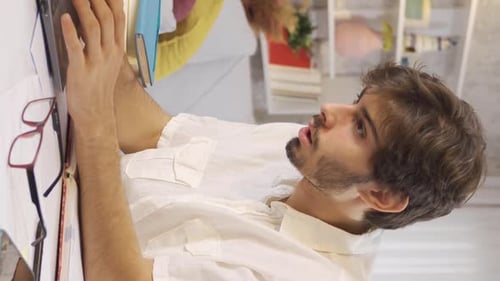 Vertical Video of University student reading a book. The student is reading a book and dancing.